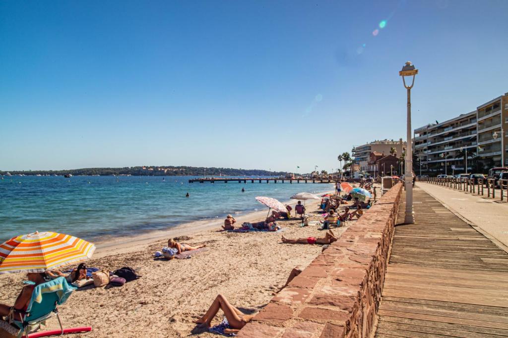 a group of people on a beach near a pier at Charmant 2p proche des plages, appartement Céladon in Cannes
