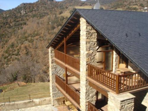 a building with a black roof and a balcony at L'Era de Cal Bastida in Estamariu