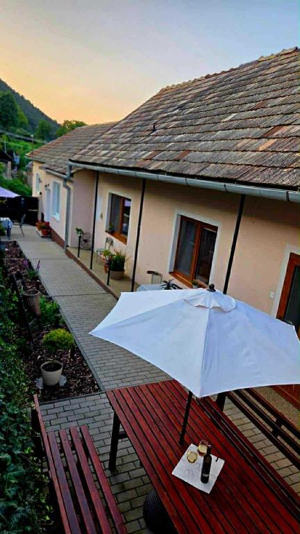 a white umbrella sitting on a picnic table in front of a house at Apartmány Magnólia Štítnik in Štítnik