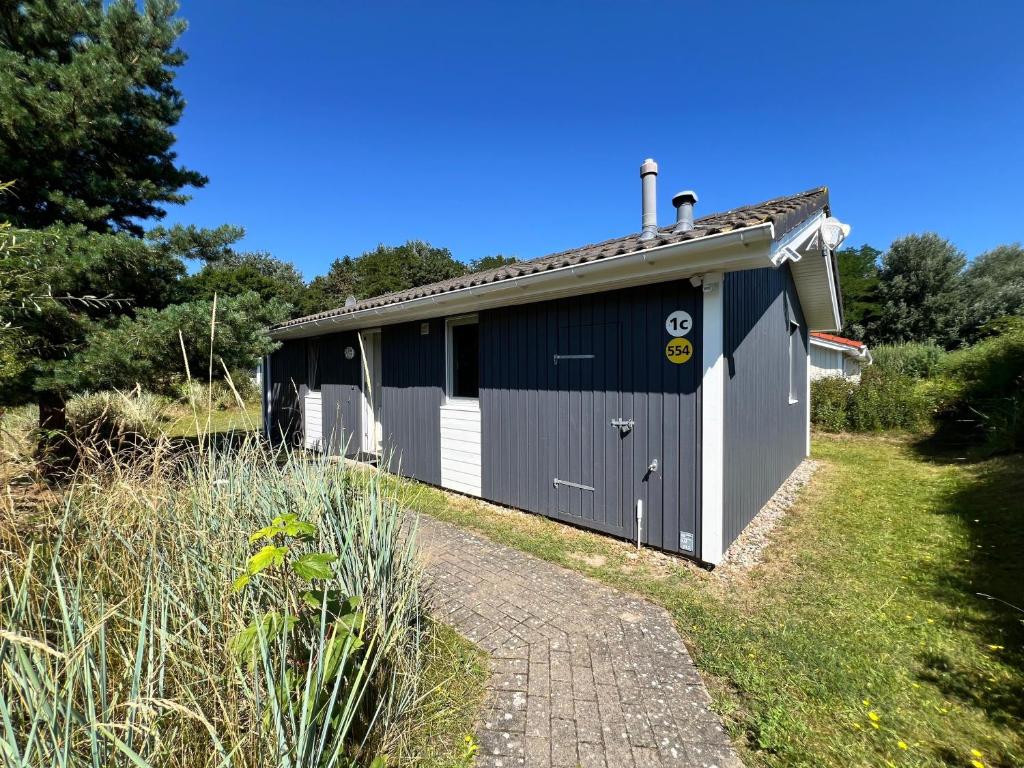 a blue and white building next to a path at Strandhaus Dünenpark 1c in Priwall