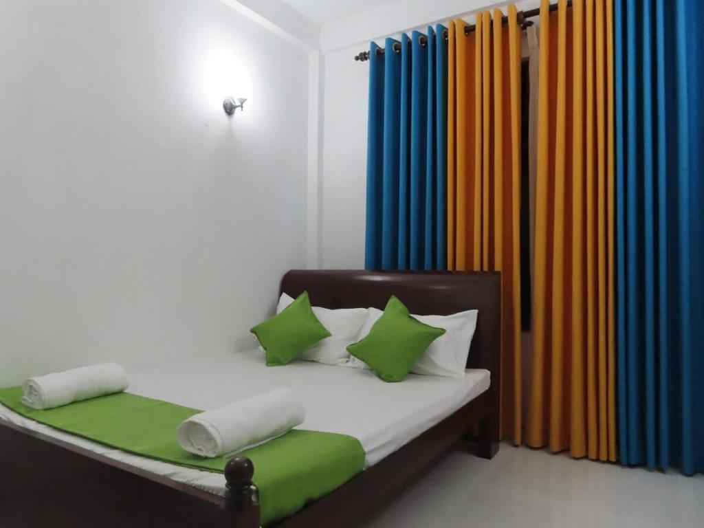 a bed with green and white pillows in a room at Holiday Home - SuSu Villa in Arangala