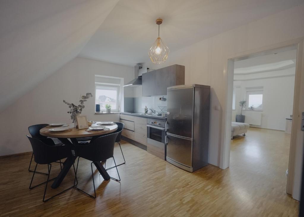 a kitchen with a table and a stainless steel refrigerator at Rezidenca Vista Lux in Ptuj