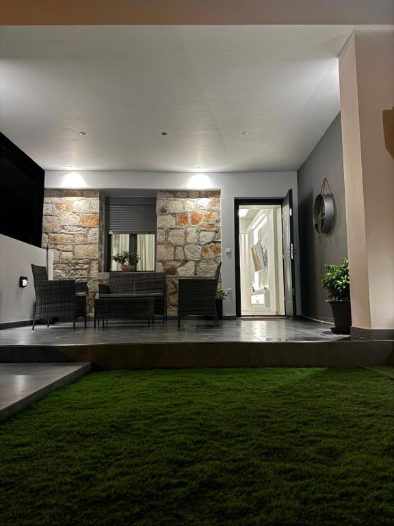 a living room with a stone wall and a green rug at George luxury stone apartment in Vonitsa