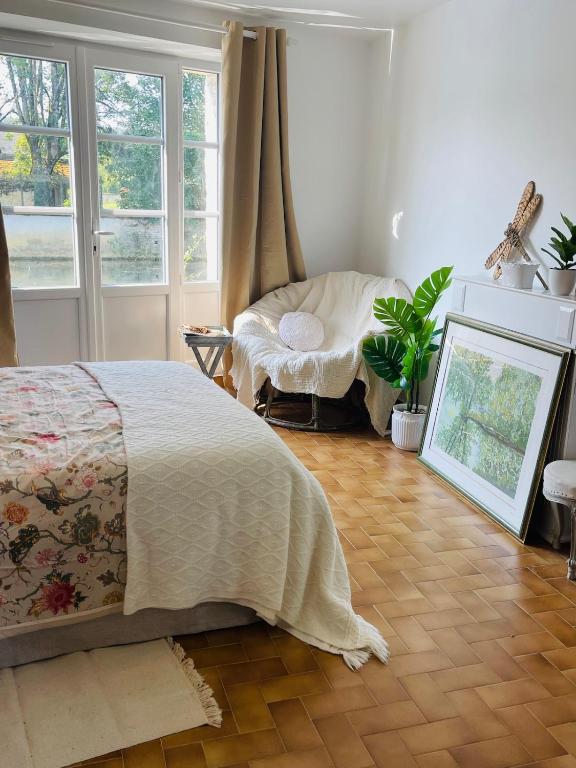 a bedroom with a bed and a table and windows at 2 rooms with garden in Longchamp-sur-Aujon
