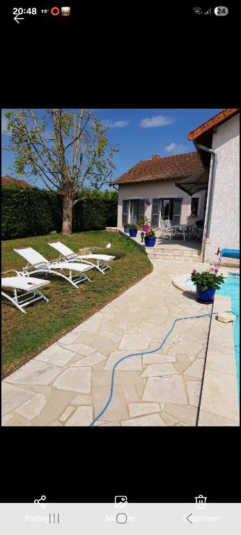 a patio with lounge chairs and a swimming pool at Le bureau in Digoin