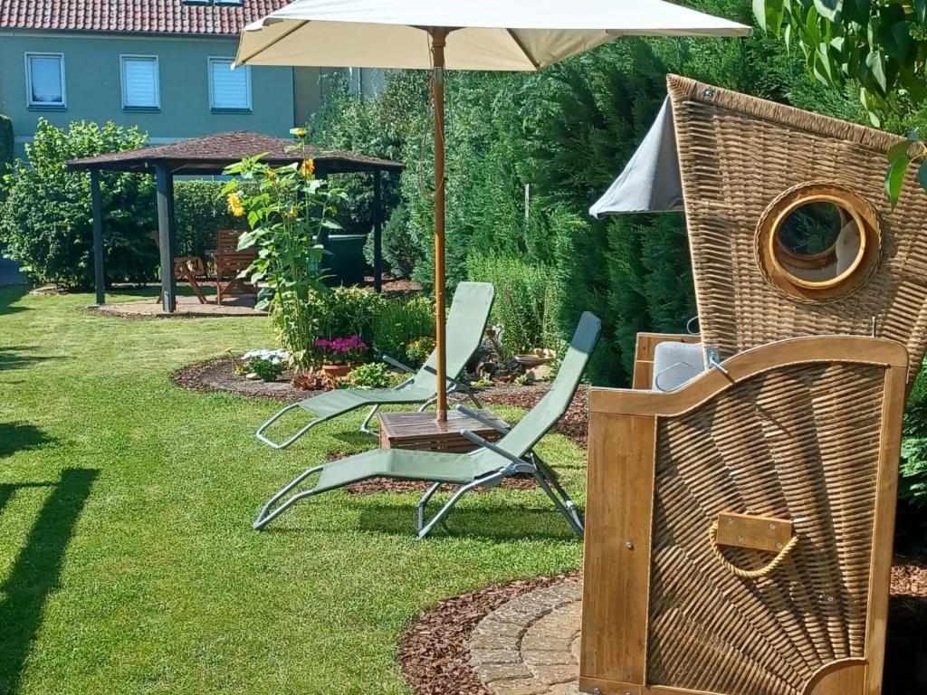 a couple of chairs and an umbrella in a yard at Ferienwohnung Am Ueckerpark in Ueckermünde
