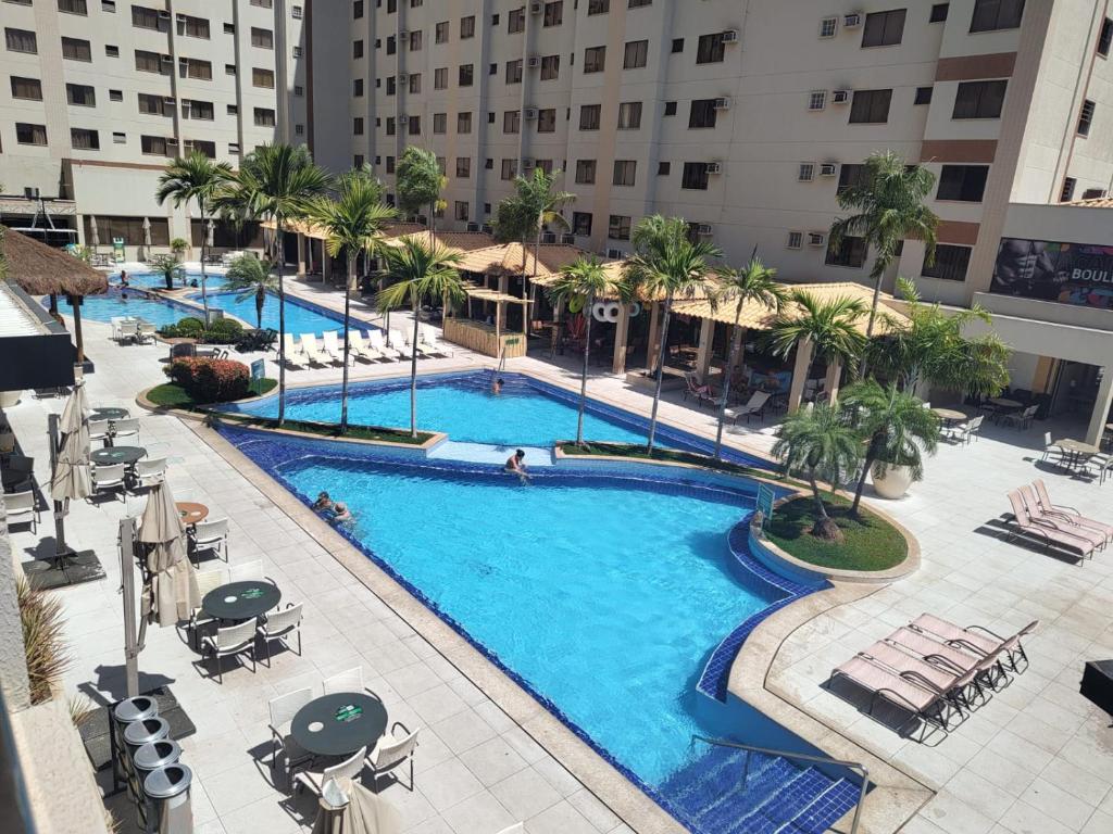 Una vista aérea de una piscina con palmeras y edificios. en Boulevard Suítes Host Hub, en Caldas Novas