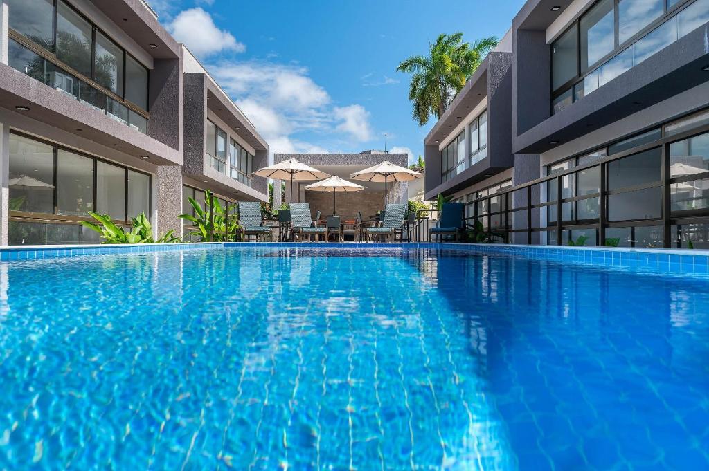 バーハ・グランデにあるSeu refúgio à poucos passos da Praia e da Vila!の建物の前の大きなプール