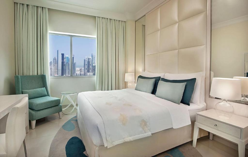 ドバイにあるMayfair Luxury Apartment in 5-Star DAMAC Maison Mall Street Building, Downtown Dubaiのベッドと机と椅子のある寝室
