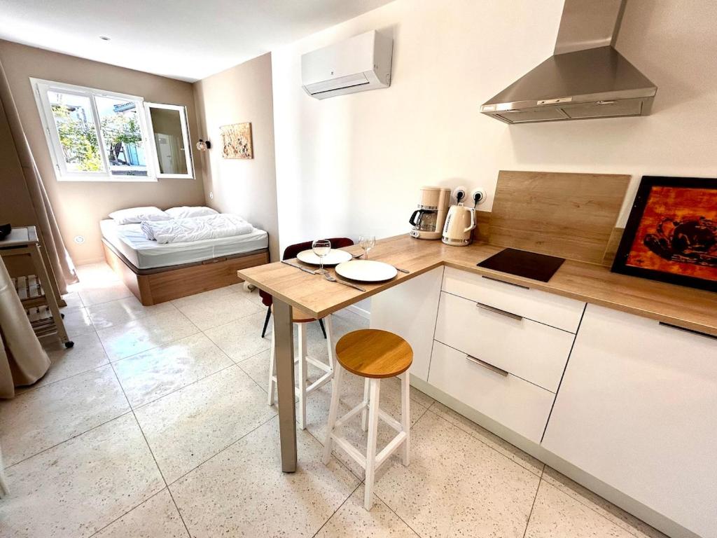 a kitchen with a counter and a table in a room at Les Gîtes du Petit Bois CHEVREFEUILLE in Ruoms
