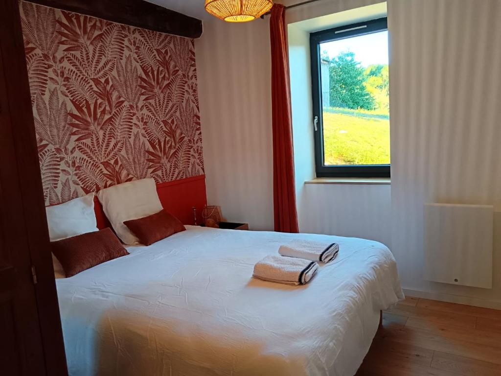 a bedroom with a bed with two towels on it at La Cornaline in Le Chalon
