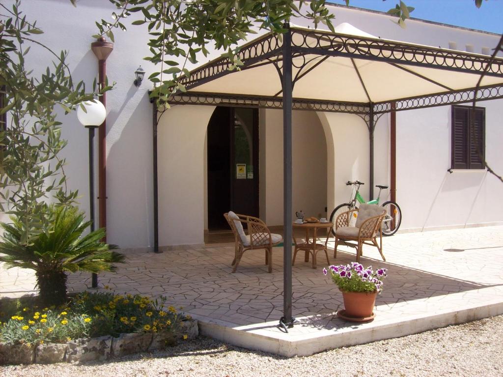 une terrasse avec une table et des chaises sous un parasol dans l'établissement Otranto Le Sancinare, à Casamassella