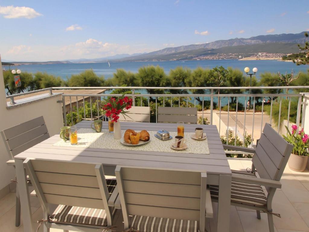 a dining table on a balcony with a view of the water at Apartment Kristijan in Šilo
