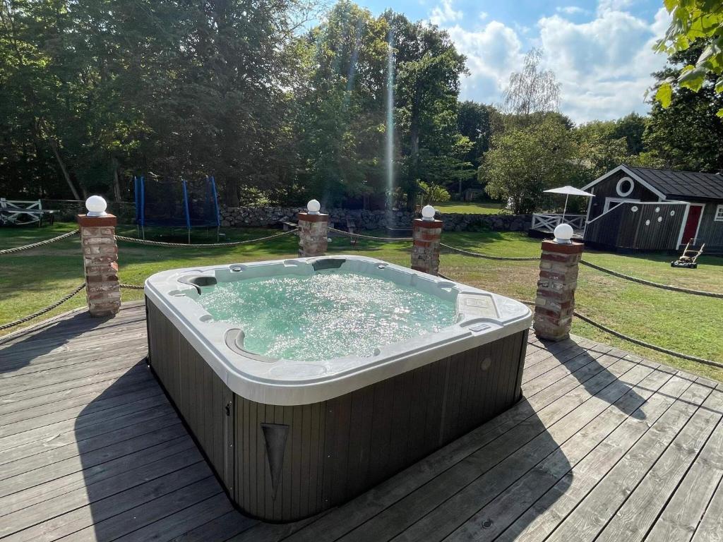 a hot tub on a wooden deck with a fountain at 4 star holiday home in Drottningskär in Drottningskär