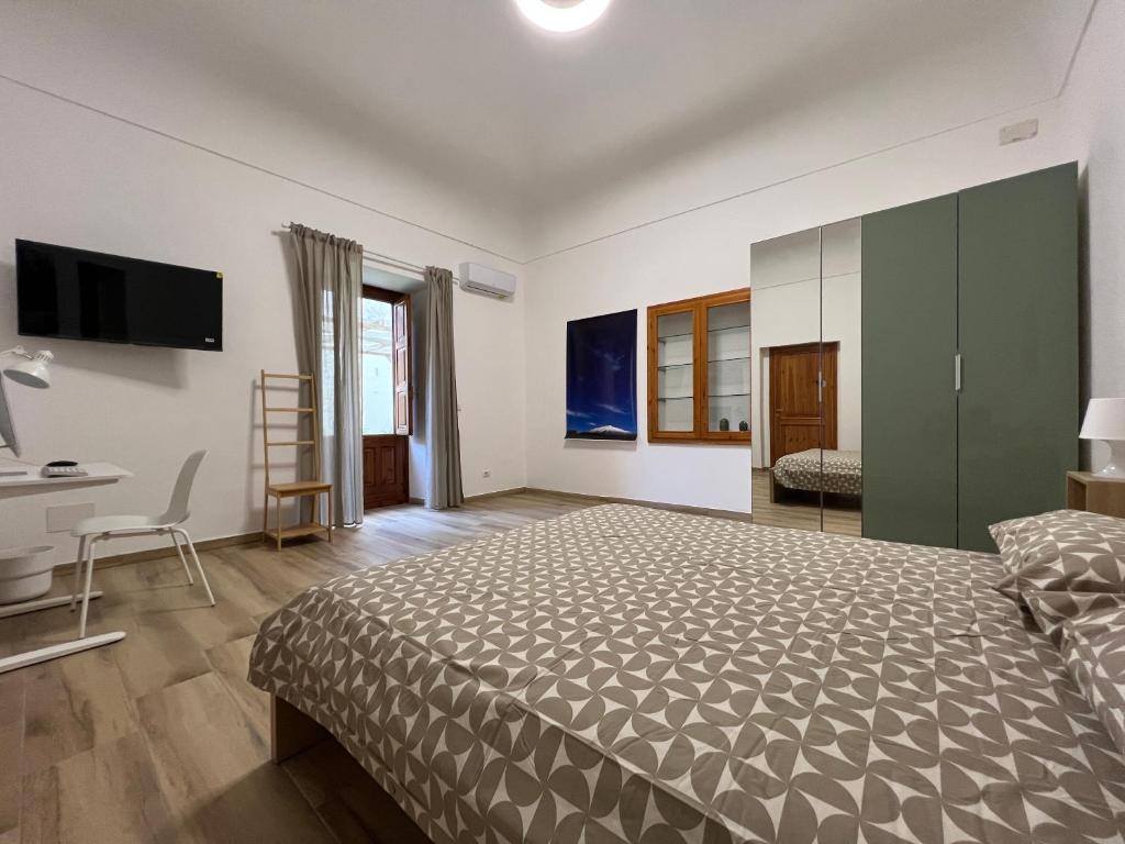 a bedroom with a bed and a desk and a television at Villa Don Minzoni in Misterbianco
