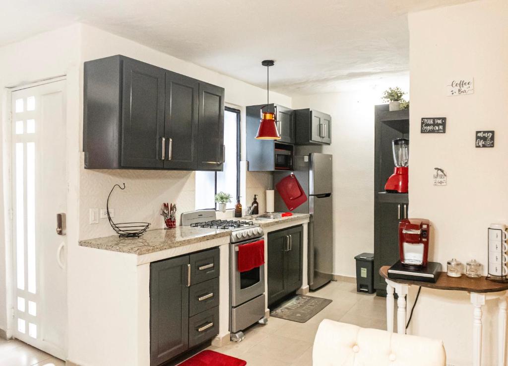 a kitchen with black cabinets and a stove top oven at Casa Cabo Paraiso in Cabo San Lucas