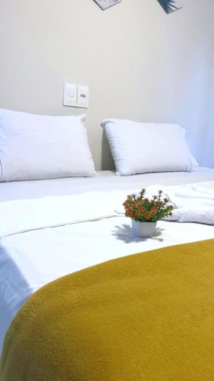a white bed with a potted plant on top of it at Pousada do Trinta in Fernando de Noronha