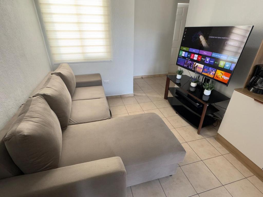een woonkamer met een bank en een flatscreen-tv bij Chill House 