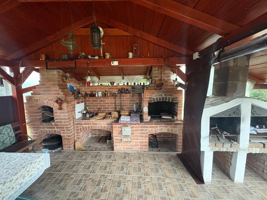 Una gran chimenea de ladrillo en una habitación con suelo de ladrillo. en Casa Maria, en Haieu