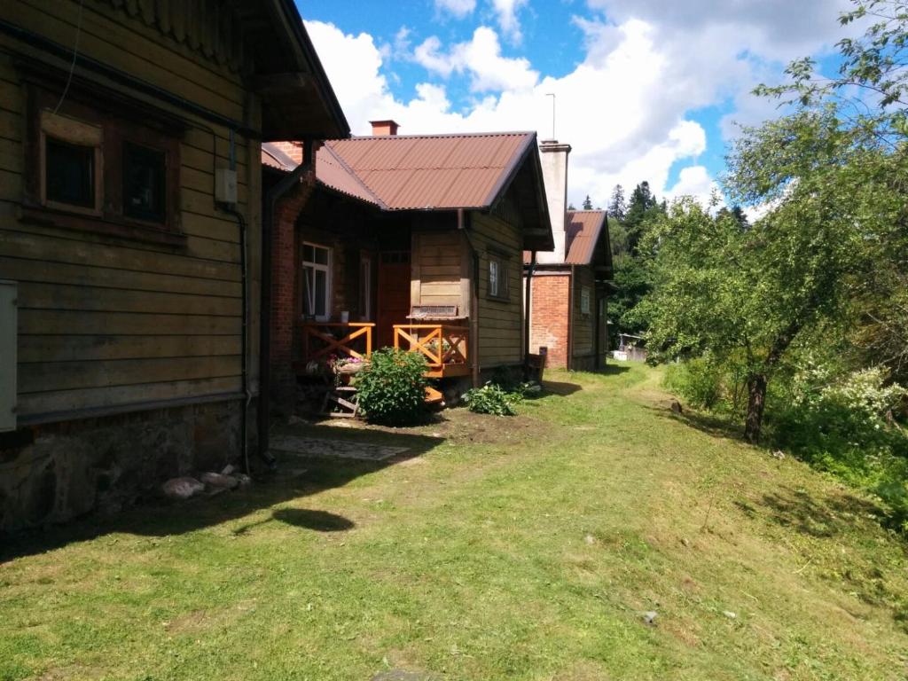 a house with a yard next to a building at Viesu Nams Vilhelmīne in Līgatne