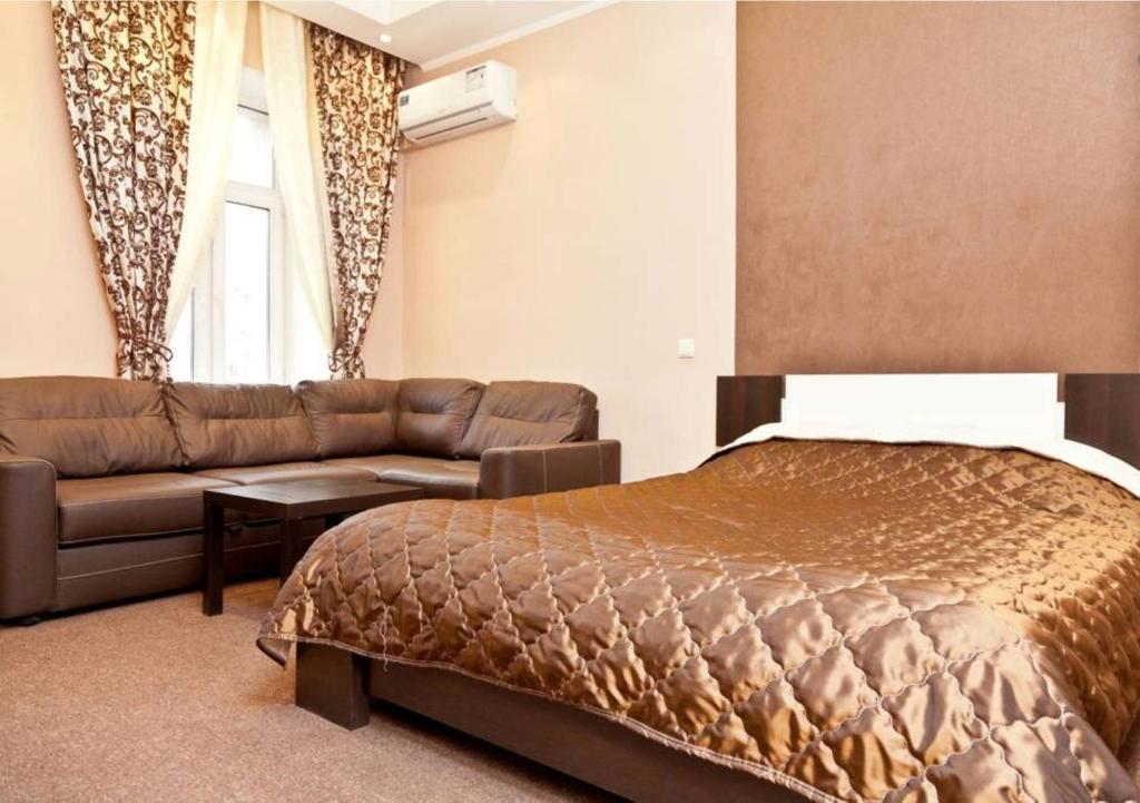 1 dormitorio con 1 cama y 1 sofá en City Apartments Taganskaya, en Moscú
