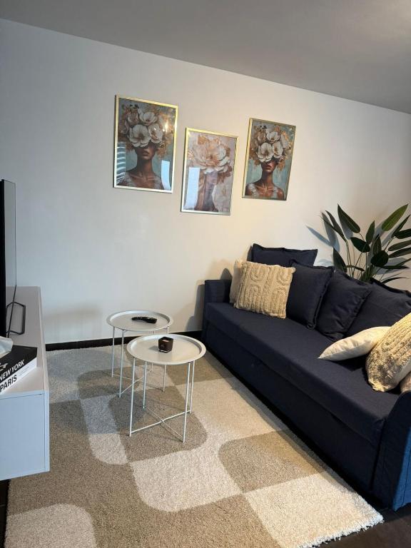 a living room with a blue couch and a table at Urban Cocoon in Liège