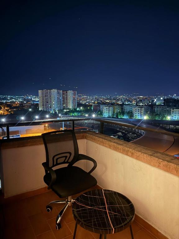 a chair sitting on top of a balcony at night at Richard Home in Tirana