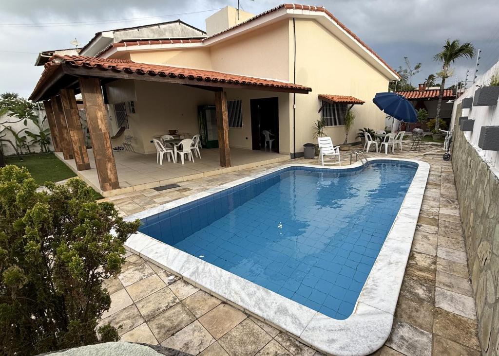 a swimming pool in front of a house at Casa de Praia Encanto Tamandaré - A 300m das Piscinas Naturais in Tamandaré