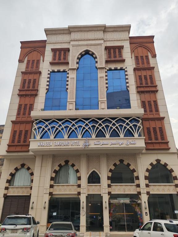 a building with windows and cars parked in front of it at فندق مواسم سمرقند اجياد توصيل مجانى للحرم in Al Masfalah