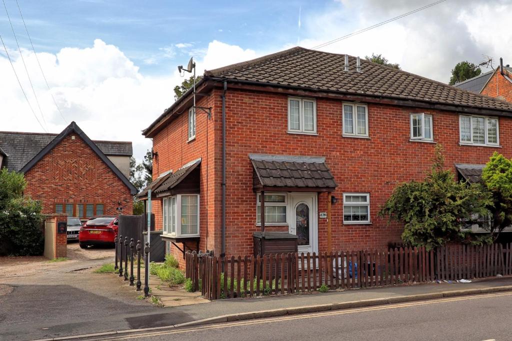 a red brick house with a wooden fence at Quirky 2-Bed Brentwood Home Near High St & Station - With Parking in Brentwood