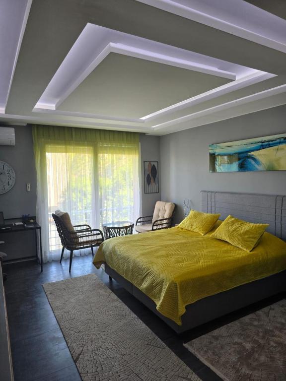 a bedroom with a large bed with a yellow blanket at Pretty Modest Apartment in Prizren