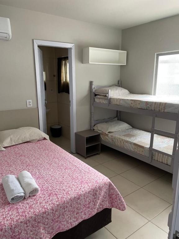 a bedroom with two bunk beds and a pink blanket at Pousada vida e mar in Balneário Camboriú