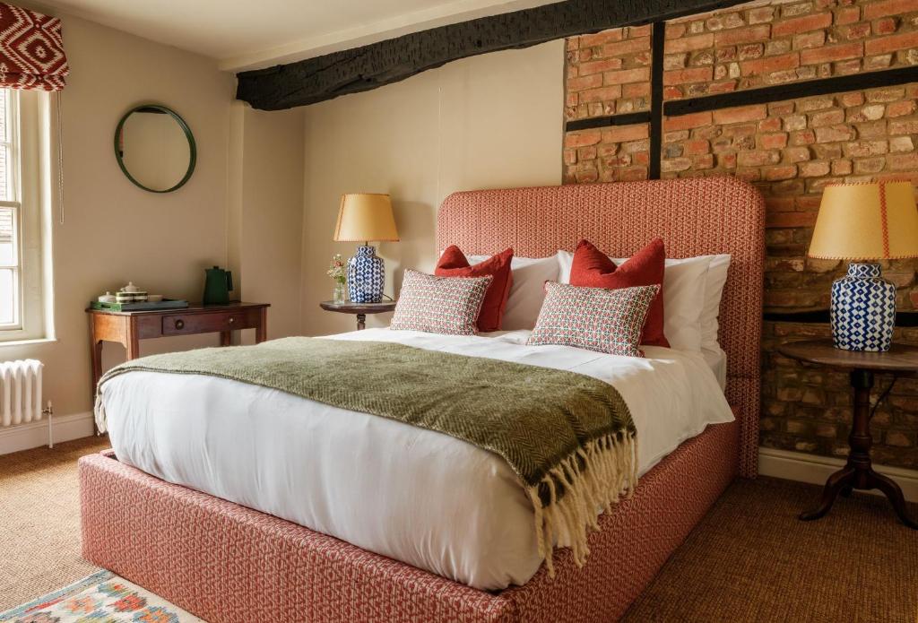 a bedroom with a large bed with a red headboard at Fleur de Lys Inn, Cranborne in Cranborne