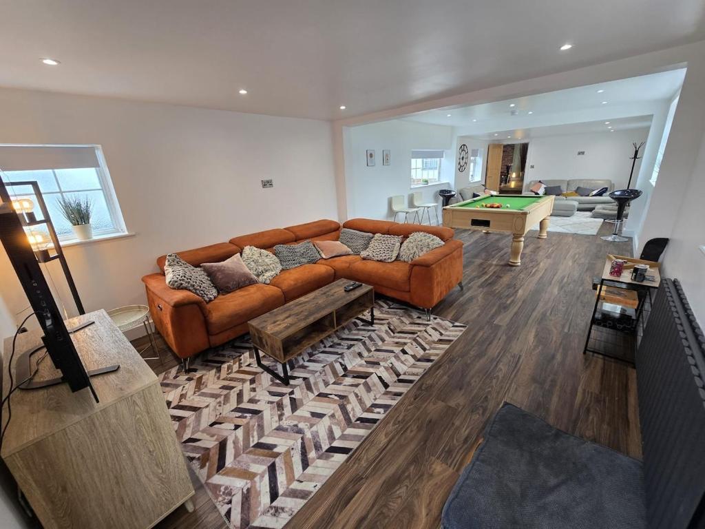 a living room with a couch and a pool table at 5 Bed Cottage Free Parking in Stainforth