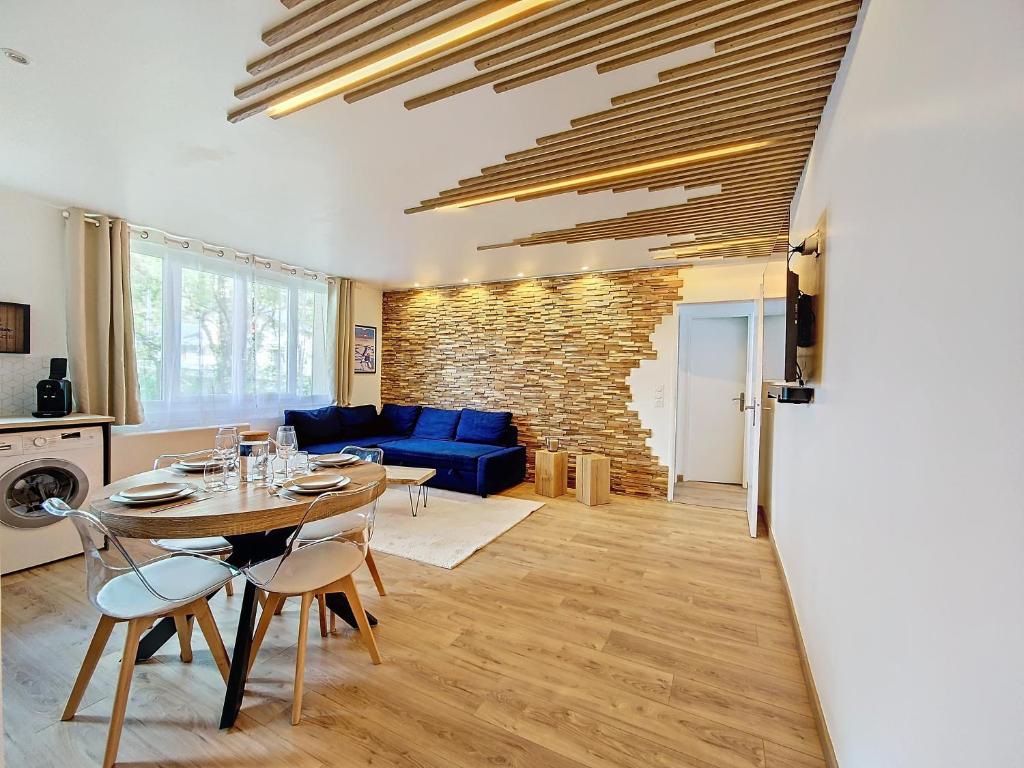 a living room with a table and a blue couch at Le Lodge de l'One in Luchon