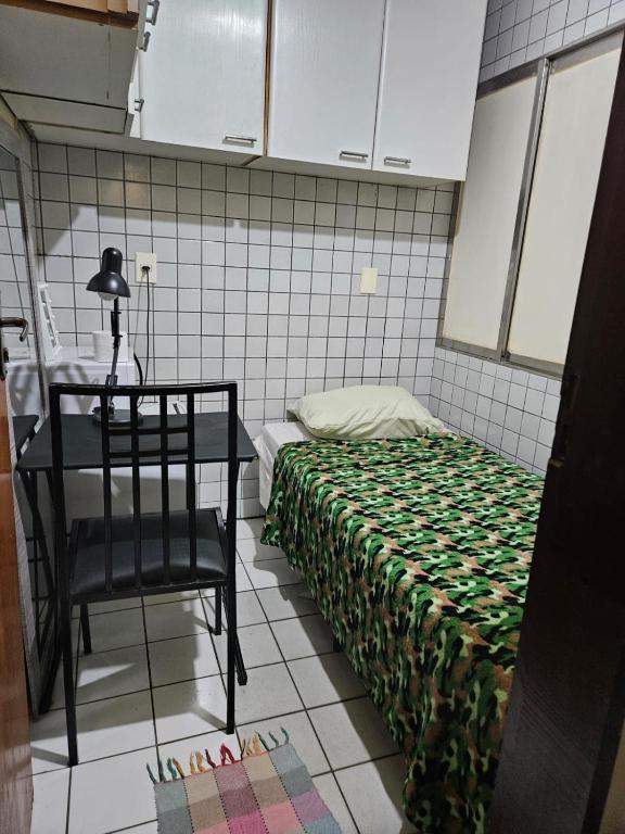 a bedroom with a bed and a table and a chair at Quarto Capsula 1 207 in Brasília