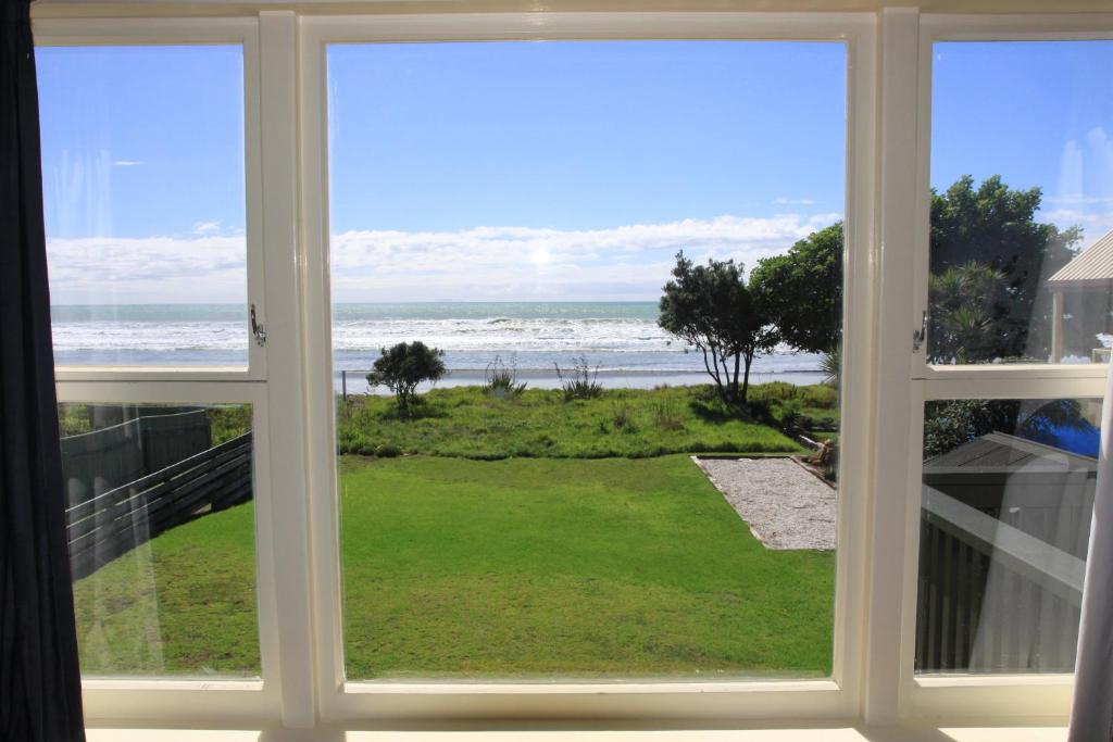 a window view of the ocean from a house at KBHH - Beachfront Paradise - BUR1 in Ohope Beach