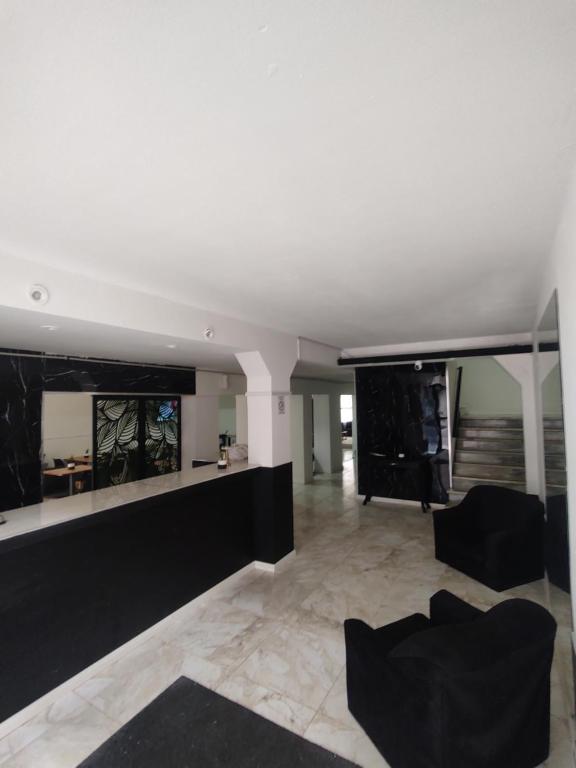 a living room with a white ceiling and black furniture at Hotel LE MIRAGE in Mar del Plata