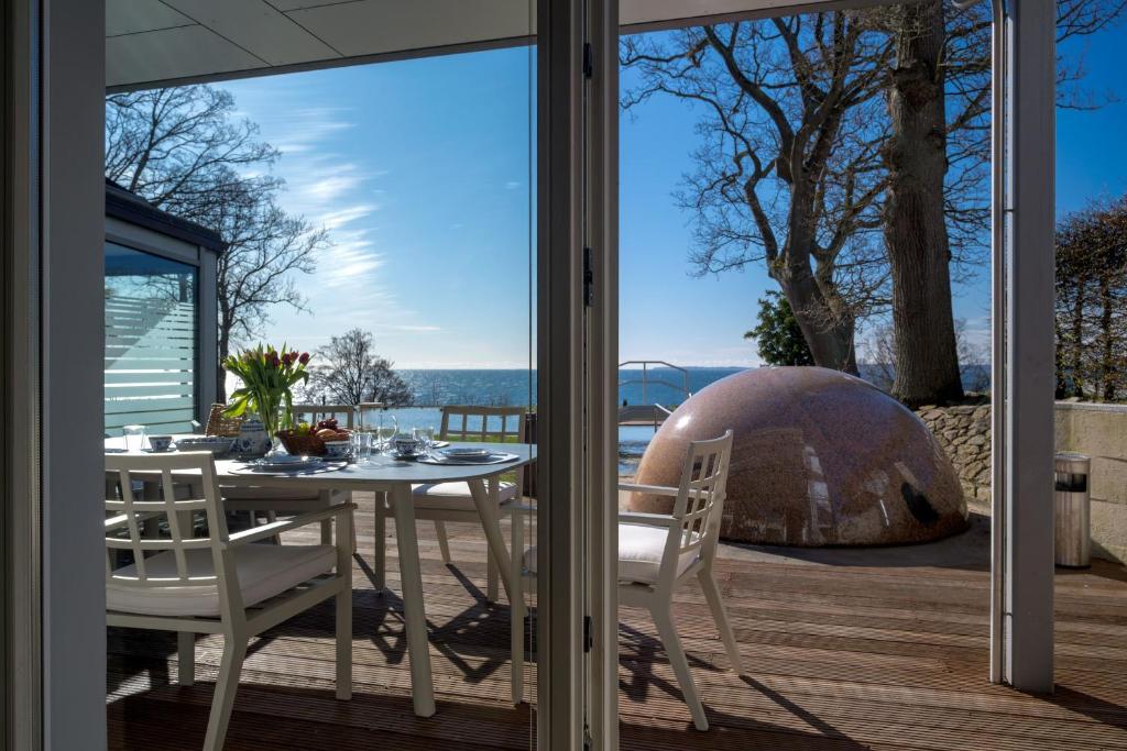 a table and chairs on a patio with a view of the ocean at FeWo Silbermöwe - Meerblick,Terrasse, Sauna, Fitness in Sassnitz