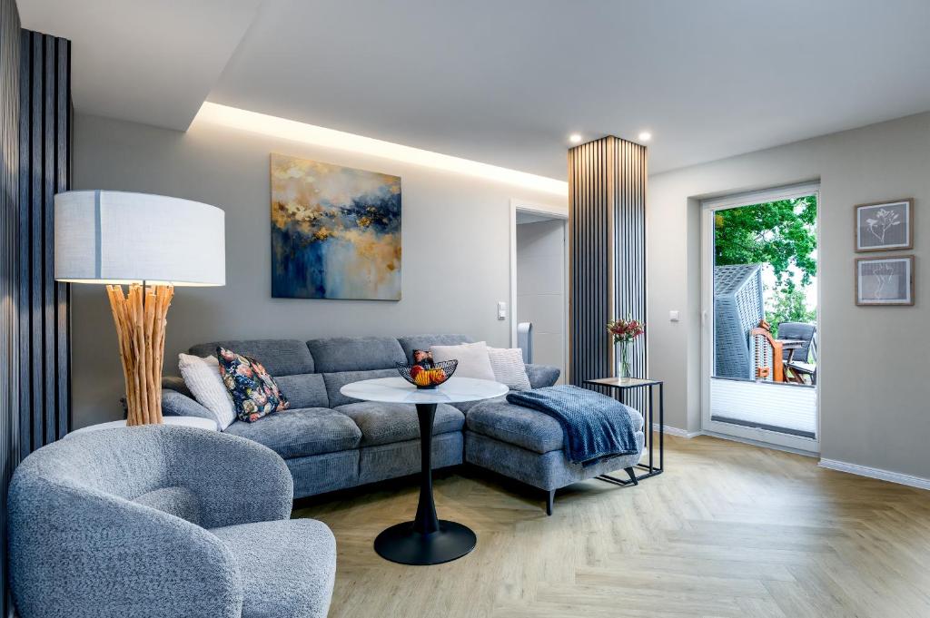 a living room with a couch and a table at FeWo Ostsee Lounge - Meerblick, Sauna, Terrasse in Sassnitz
