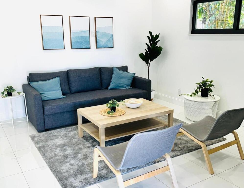 a living room with a couch and a table and chairs at Palm Breeze Getaway in Hollywood