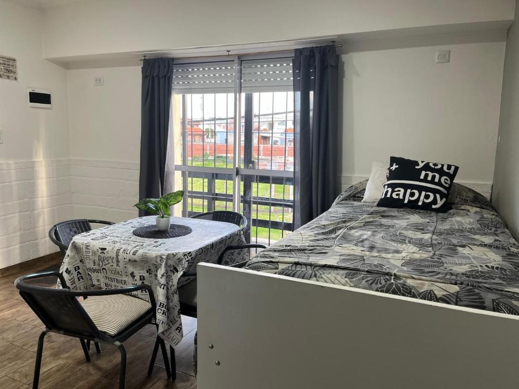 une chambre avec un lit, une table et une fenêtre dans l'établissement Planta Alta con Balcon, à Mar del Plata