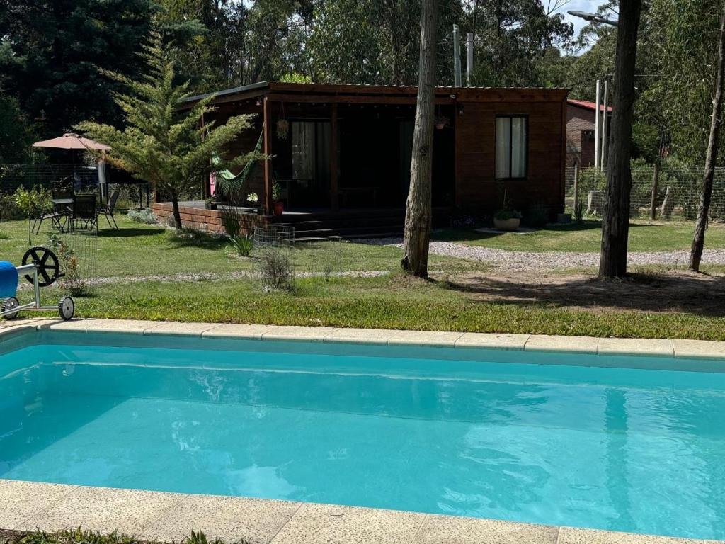 una piscina di fronte a una cabina di Amuleto Cabañas, Bella Vista, Maldonado a Bella Vista