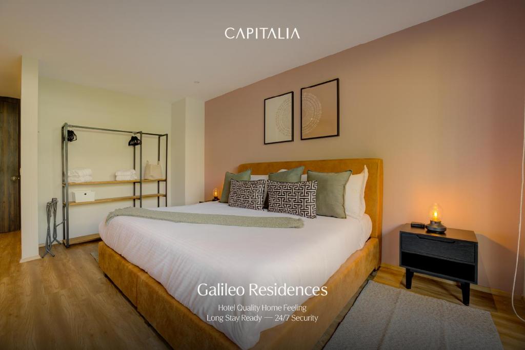 a bedroom with a large bed and a table at Capitalia Galileo Residences in Mexico City