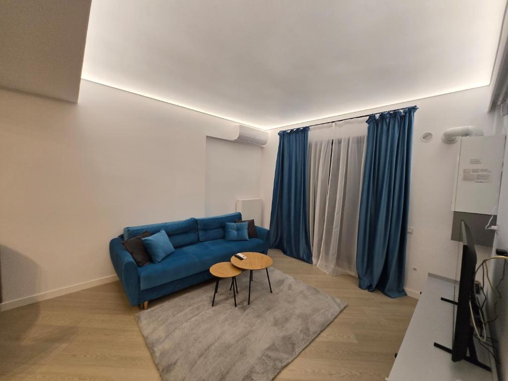 a living room with a blue couch and a table at Luxury Pipera 3Rooms Apartament in Voluntari