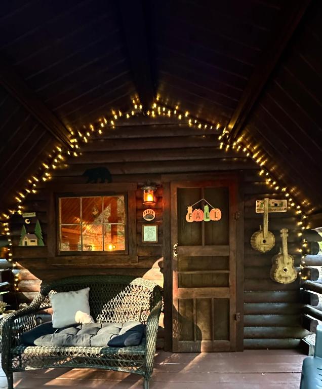 a porch with a couch and lights in a cabin at The Drake Cabin in The Forest in Cosby