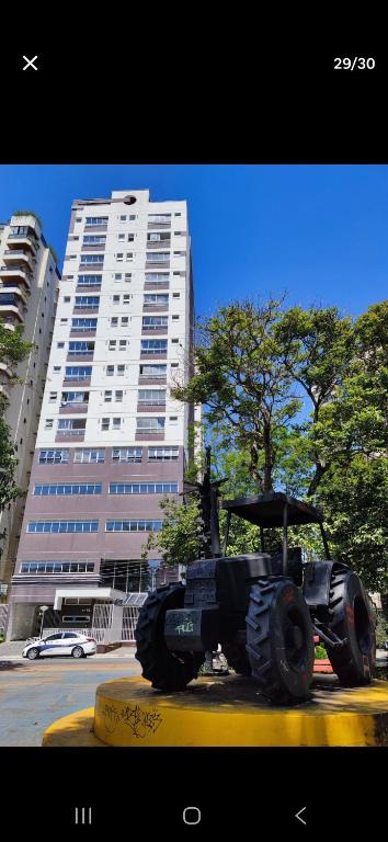 a statue of a tractor in front of a building at Loft, seu espaço com conforto in Mogi das Cruzes