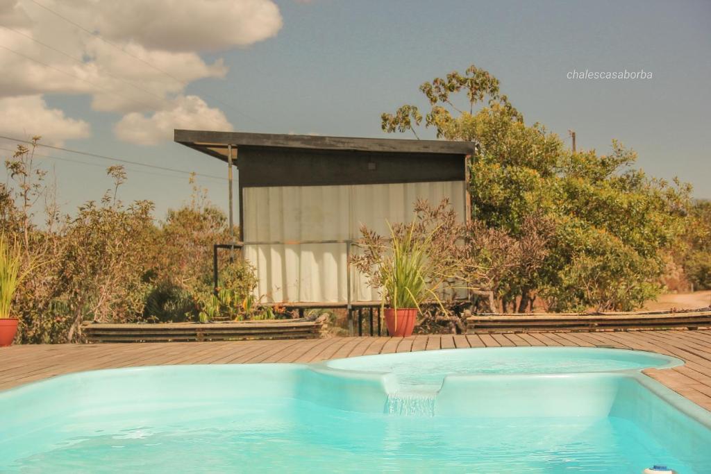 a swimming pool in a yard with a building at Casa Borba Chalé com piscina in Alto Paraíso de Goiás