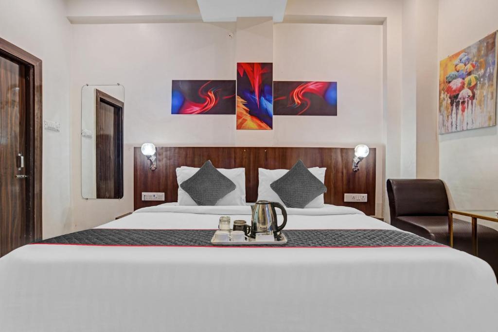 インドールにあるSuper Townhouse Hotel O Benchmarkの大きなベッドと椅子のあるホテルの部屋