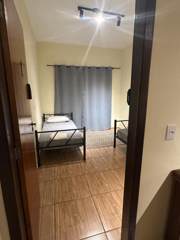 a room with a bed and a window with a ceiling at Pousada Araquari in Paraty